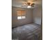 This is a cozy bedroom featuring comfortable carpeting, natural light, and a ceiling fan at 5501 S Dove Crk Crk, Buckeye, AZ 85326