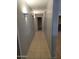 Neutral tiled hallway with wall lighting and an open view to the living room at 5501 S Dove Crk Crk, Buckeye, AZ 85326