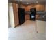Well-lit kitchen featuring light wood cabinets, black appliances, durable countertops and tile flooring at 5501 S Dove Crk Crk, Buckeye, AZ 85326