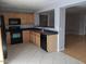 Spacious kitchen featuring black appliances, light wood cabinets, black countertop, and tile flooring at 5501 S Dove Crk Crk, Buckeye, AZ 85326