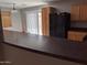 A kitchen featuring wooden cabinetry, a black refrigerator, and a dark countertop at 5501 S Dove Crk Crk, Buckeye, AZ 85326