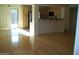 Open-concept living room with hardwood floors connecting to kitchen and sliding glass door at 5501 S Dove Crk Crk, Buckeye, AZ 85326