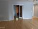 Bright living room with hardwood floors leading to a room with wooden blinds through glass french doors at 5501 S Dove Crk Crk, Buckeye, AZ 85326