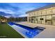 Beautiful backyard pool with modern patio, fireplace, and seamless indoor-outdoor living through large glass doors at 6601 E San Miguel Ave, Paradise Valley, AZ 85253