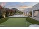 Backyard putting green with flags, sand trap, and lush landscaping, mountain views and modern architecture at 6601 E San Miguel Ave, Paradise Valley, AZ 85253