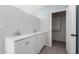 Bright bathroom with double sinks, white cabinets, and access to a walk-in closet at 6767 N 7Th St # 212, Phoenix, AZ 85014