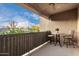 Cozy covered balcony featuring a small dining table and chairs with exterior views of the neighborhood at 7021 E Earll Dr # 223, Scottsdale, AZ 85251