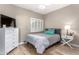 Bright bedroom with a bed, white dresser, and wood-look flooring at 7021 E Earll Dr # 223, Scottsdale, AZ 85251