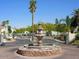 Elegant gated community entrance with a decorative water fountain and meticulously landscaped grounds at 7021 E Earll Dr # 223, Scottsdale, AZ 85251