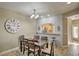 Comfortable dining area featuring a wooden table set, decorative wall clock, and bar access to the kitchen at 7021 E Earll Dr # 223, Scottsdale, AZ 85251