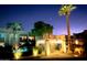 Night view of a lit pool with nearby cabana and palm trees, creating a tropical ambiance at 7021 E Earll Dr # 223, Scottsdale, AZ 85251