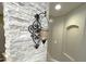 Elegant wall sconce accenting the white stone wall feature near the stairway at 7021 E Earll Dr # 223, Scottsdale, AZ 85251