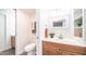 Well-lit bathroom featuring wood-finish vanity and practical sliding-door storage at 7928 N 46Th Ave, Glendale, AZ 85301