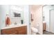 Bright bathroom with wood vanity, decorative mirror, and separate toilet room at 7928 N 46Th Ave, Glendale, AZ 85301