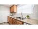 Close-up on a granite countertop with a stainless steel sink and wood cabinets in the kitchen at 7928 N 46Th Ave, Glendale, AZ 85301