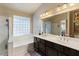 Spacious bathroom featuring dual sinks, glass block window, and a glass shower enclosure at 804 N Jamaica Way, Gilbert, AZ 85234