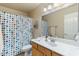 Bright bathroom featuring a sink with a white countertop and a shower with a colorful curtain at 804 N Jamaica Way, Gilbert, AZ 85234