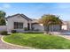 Charming single-story home with a well-manicured lawn and a mature flowering tree in the front yard at 804 N Jamaica Way, Gilbert, AZ 85234
