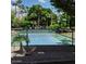 Tennis court surrounded by lush greenery offers a private and shaded space for recreational activities at 804 N Jamaica Way, Gilbert, AZ 85234