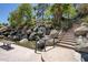 Picturesque water feature with a waterfall cascading over natural rocks and lush greenery at 804 N Jamaica Way, Gilbert, AZ 85234