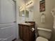 This bathroom is designed with wood cabinets, a dual-bulb vanity light, and a decorative painting at 8700 E University Dr # 1024, Mesa, AZ 85207