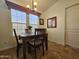 Cozy dining area with a chandelier, four chairs, and ample natural light from the window at 8700 E University Dr # 1024, Mesa, AZ 85207