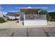 Charming home showcasing a covered front porch with awning and white railings, complemented by a blue sky backdrop at 8700 E University Dr # 1024, Mesa, AZ 85207