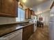 Functional kitchen showcasing wooden cabinetry, a stainless steel sink, and white appliances, adjacent to a dining area at 8700 E University Dr # 1024, Mesa, AZ 85207