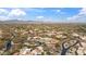 Aerial view of desert homes with desert landscaping and a green golf course, mountains in the background at 9110 E Clubhouse Ct # 639, Scottsdale, AZ 85262