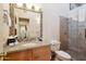 Well-lit bathroom features a granite countertop, decorative mirror, and tiled shower with glass door at 9110 E Clubhouse Ct # 639, Scottsdale, AZ 85262