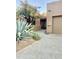 A desert-landscaped front entrance with a wood door and two-car garage is warm and inviting at 9110 E Clubhouse Ct # 639, Scottsdale, AZ 85262