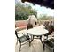 Cozy outdoor patio with table, chairs, and outdoor fireplace with seating and mature landscaping at 9110 E Clubhouse Ct # 639, Scottsdale, AZ 85262