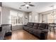 Comfortable living room showcasing a ceiling fan, plush sofa, and tiled flooring at 925 S Storment Ln, Gilbert, AZ 85296