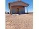 Exterior side view of guest house, showcasing stone columns and a rustic, wooden entry door at 9312 S Watson Rd, Buckeye, AZ 85326