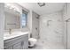 Bathroom featuring marble-look tile, gray vanity, and a window for natural light at 9711 W Edward Dr, Sun City, AZ 85351