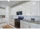 Kitchen featuring granite countertops, stainless appliances, subway tile backsplash, and white cabinets at 9818 E Talon Ave, Mesa, AZ 85212