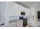 Well-lit kitchen features granite countertops, stainless appliances, subway tile backsplash, and white cabinets at 9818 E Talon Ave, Mesa, AZ 85212