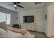 Primary suite featuring a window, ceiling fan, dresser with TV, and a green accent chair at 9818 E Talon Ave, Mesa, AZ 85212