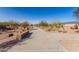 View of the community street featuring desert landscaping and mature trees at 1060 W Castle Ct, Casa Grande, AZ 85122