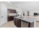 Modern kitchen with granite countertops, stainless steel appliances, dark cabinetry, and an island that opens to the living area at 1060 W Castle Ct, Casa Grande, AZ 85122