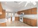 Kitchen with white appliances, wooden cabinets and view to living room at 10856 E Kiva Ave, Mesa, AZ 85209