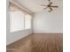 Bright living room featuring beautiful hardwood floors, a ceiling fan, and a large window for natural light at 10856 E Kiva Ave, Mesa, AZ 85209