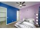 Stylish bedroom featuring custom-painted walls, ceiling fan, and a view of a large walk-in closet at 11529 N 170Th Ln, Surprise, AZ 85388