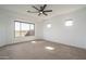 A bright and airy bedroom featuring plush carpets, ceiling fan, and large windows at 11529 N 170Th Ln, Surprise, AZ 85388