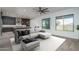 Modern living room connected to open kitchen, with large windows offering views to the backyard at 11529 N 170Th Ln, Surprise, AZ 85388