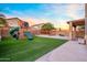 View of backyard featuring play-set, turf, and string lights at 12118 W Villa Chula Ct, Sun City, AZ 85373