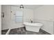 Bright bathroom with a soaking tub, step-in shower, decorative lighting, and marble tile at 12118 W Villa Chula Ct, Sun City, AZ 85373