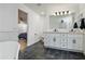 Bathroom with black tile floor, double vanity and views of the attached main bedroom at 12118 W Villa Chula Ct, Sun City, AZ 85373