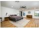 Spacious bedroom with a ceiling fan, a large rug, and wooden flooring at 12118 W Villa Chula Ct, Sun City, AZ 85373