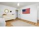 Bedroom with wood-look floors, round mirror, dresser, and patriotic decor at 12118 W Villa Chula Ct, Sun City, AZ 85373